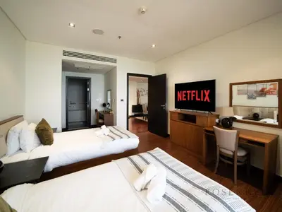 a hotel room with two beds and a television at Luxury Anantara Res - Sea & Burj AlArab View in Dubai