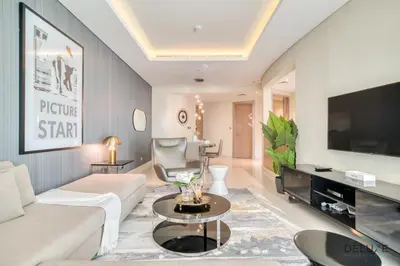 a living room with a white couch and a tv at Polished 3BR at DAMAC Towers by Paramount A Business Bay by Deluxe Holiday Homes in Dubai