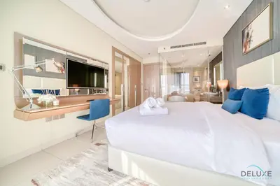 a bedroom with a large white bed and a tv at Polished 3BR at DAMAC Towers by Paramount A Business Bay by Deluxe Holiday Homes in Dubai