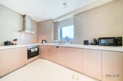 a kitchen with white cabinets and a microwave at Polished 3BR at DAMAC Towers by Paramount A Business Bay by Deluxe Holiday Homes in Dubai