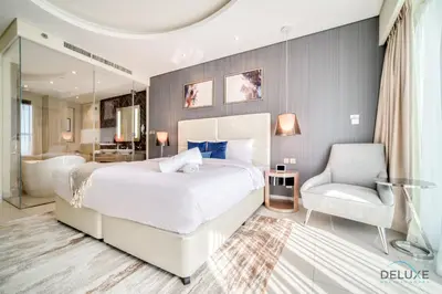 a bedroom with a large white bed and a chair at Polished 3BR at DAMAC Towers by Paramount A Business Bay by Deluxe Holiday Homes in Dubai