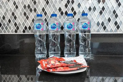 three bottles of water sitting on a table at LuxBnB Paramount Midtown SeaView in Dubai