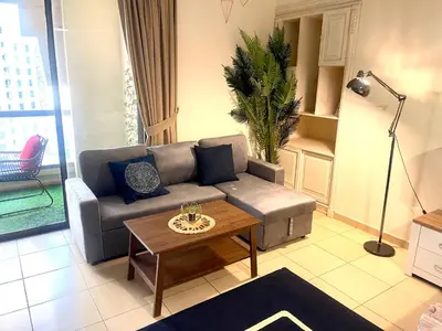 a living room with a couch and a coffee table at Charming spacious studio apartment in the heart of JBR By SWEET HOMES in Dubai