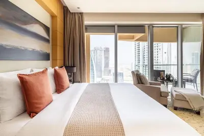 a hotel room with a large white bed with orange pillows at Frank Porter - Emaar Residences Fashion Avenue in Dubai