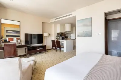 a hotel room with a bed and a living room at Frank Porter - Emaar Residences Fashion Avenue in Dubai