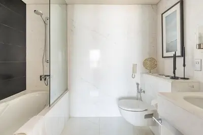 a white bathroom with a toilet and a sink at Frank Porter - Emaar Residences Fashion Avenue in Dubai