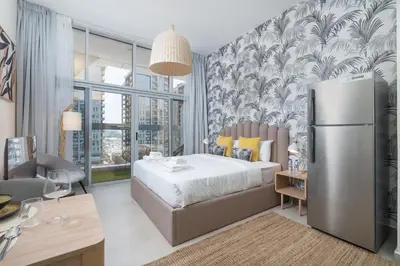 a bedroom with a bed and a refrigerator at Lovely Studio & Budget Friendly in Dubai