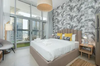 a bedroom with a large bed and a wall of windows at Lovely Studio & Budget Friendly in Dubai