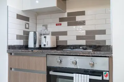 a kitchen with a stove top oven next to a counter at Lovely Studio & Budget Friendly in Dubai