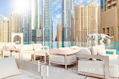 a balcony with white furniture and a view of buildings at LUX The JW Marina Suite in Dubai
