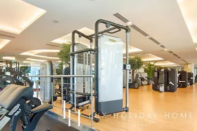 a gym with treadmills and ellipticals in a room at LUX The JW Marina Suite in Dubai