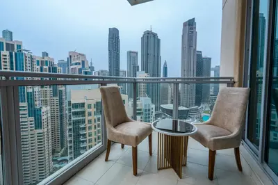 a balcony with two chairs and a table and a city at INA Homes-Residences Tower 7 Full Burj Khalifa & Fountain Views in Dubai