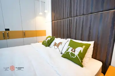 a bed with green pillows with horses on it at Modern Spacious 2BR Canal View -Business Bay in Dubai