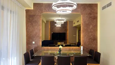 a dining room with a table and chairs and a large mirror at Elan Rimal Suites JBR Beach Sea View in Dubai