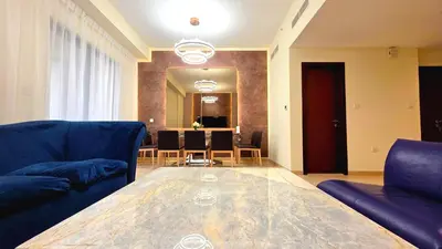 a living room with a glass table and chairs at Elan Rimal Suites JBR Beach Sea View in Dubai