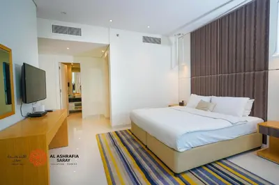 a bedroom with a bed and a flat screen tv at Al Ashrafia Saray Marvelous 1 BR - Damac Maison - Canal View in Dubai