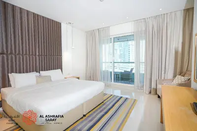a bedroom with a large bed and a large window at Al Ashrafia Saray Marvelous 1 BR - Damac Maison - Canal View in Dubai