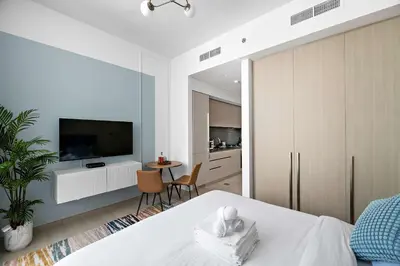 a bedroom with a bed and a tv and a table at Silkhaus modern studio in the heart of vibrant JVC in Dubai