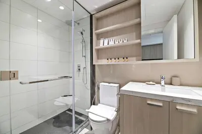 a bathroom with a shower and a toilet and a sink at Silkhaus modern studio in the heart of vibrant JVC in Dubai
