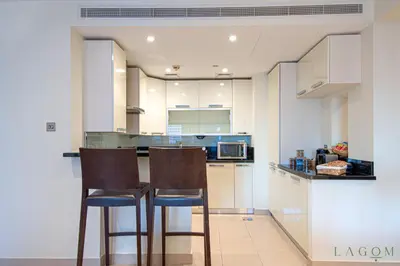 a kitchen with two bar stools and a counter at Songs of the Lake by Lagom - Bonnington Apartment Jumeirah Lake Towers, in Dubai