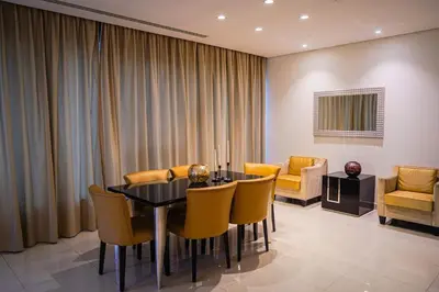 a dining room with a table and yellow chairs at Al Ashrafia Saray Magnificent 3BR Canal Views in Dubai