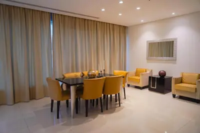 a dining room with a table and yellow chairs at Al Ashrafia Saray Magnificent 3BR Canal Views in Dubai