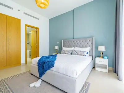 a bedroom with a large bed with blue walls at Downtown Charming Condo Close to Dubai Mall in Dubai