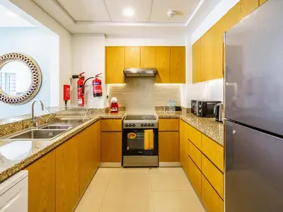 a kitchen with wooden cabinets and a stove top oven at Downtown Charming Condo Close to Dubai Mall in Dubai