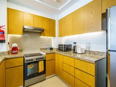 a kitchen with wooden cabinets and a stove at Downtown Charming Condo Close to Dubai Mall in Dubai