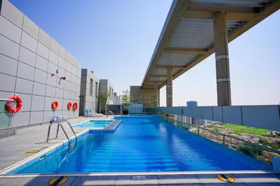 a swimming pool on the roof of a building at Alasharafia Saray, Spacious 1BR apartment in Sport City in Dubai