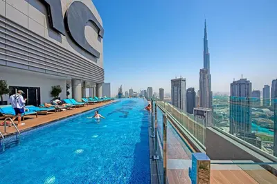 a pool on the top of a building with people in it at La Dolce Vita Residence by Suiteable Interiors in Dubai
