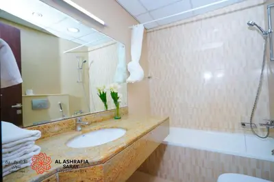 a bathroom with a sink and a tub and a mirror at Alashrafia Saray, Charming 1BR apartment in Sport City in Dubai