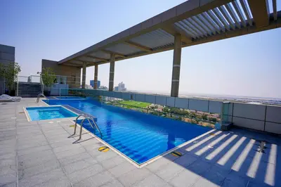 a swimming pool on the roof of a building at Alashrafia Saray, Charming 1BR apartment in Sport City in Dubai