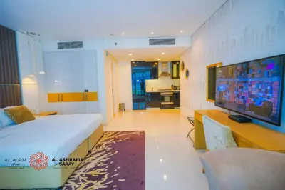 a bedroom with a large bed and a tv in a room at Al Ashrafia Saray - Extraordinary Studio in Canal View in Dubai
