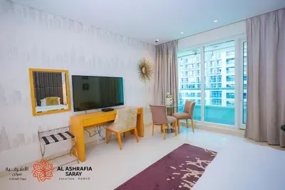 a living room with a television and a table with chairs at Al Ashrafia Saray - Extraordinary Studio in Canal View in Dubai