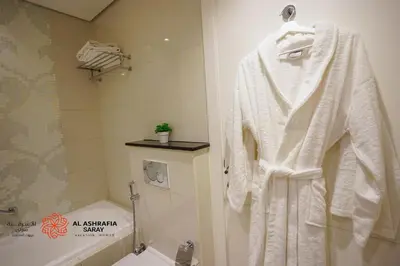 a bathroom with a white robe hanging on a rack at Al Ashrafia Saray - Extraordinary Studio in Canal View in Dubai