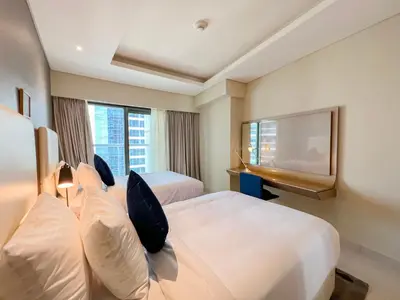 a hotel room with two beds and a flat screen tv at Luton Vacation Homes - Damac Paramount 2BR High Floor, Business Bay, Dubai 61AB06 in Dubai