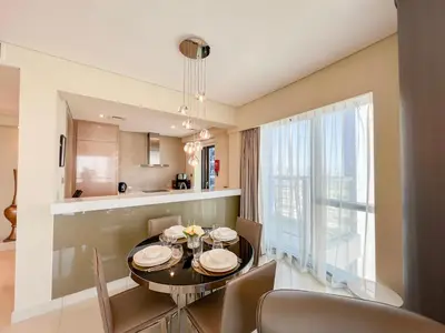 a dining room and kitchen with a table and chairs at Luton Vacation Homes - Damac Paramount 2BR High Floor, Business Bay, Dubai 61AB06 in Dubai