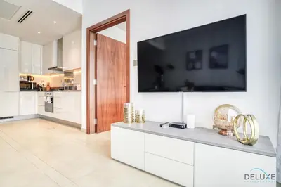 a large white kitchen with a flat screen tv on the wall at Surreal 1BR at The Residence Marina Gate 2 Dubai Marina by Deluxe Holiday Homes in Dubai
