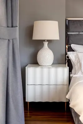a white lamp on a night stand next to a bed at Luxury 1 bedroom with amazing full sea view! in Dubai
