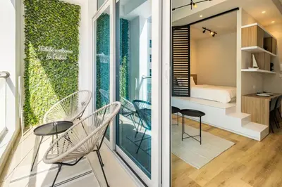 a room with a balcony with chairs and a bed at Exclusive Designer Studio by Marina, Beach & Mall in Dubai