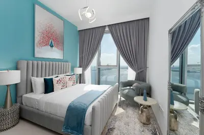 a bedroom with blue walls and a bed and a chair at Maison Privee - Trendy Apt on the Creek w/ Superb Dubai Skyline Vw in Dubai