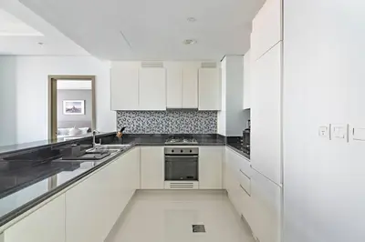 a white kitchen with white cabinets and appliances at StoneTree - Paramount Tower Hotel&Residences 3 BR - Sea View and Infinity Pool in Dubai