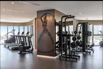 a gym with a woman painted on the wall at StoneTree - Paramount Tower Hotel & Residences 2 BR - Infinity Pool & Stunning View in Dubai