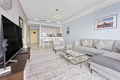 a living room with a couch and a flat screen tv at StoneTree - Paramount Tower Hotel & Residences 2 BR - Infinity Pool & Stunning View in Dubai