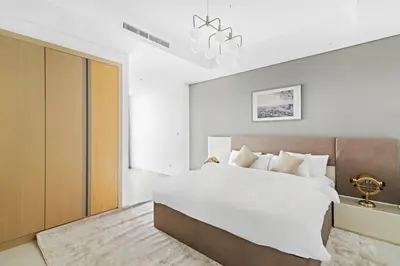 a bedroom with a large white bed and a chandelier at StoneTree - Paramount Tower Hotel&Residences 2 BR - Amazing View in Dubai
