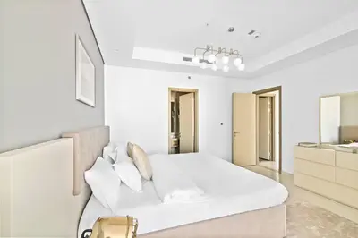 a white bedroom with a white bed and a sink at StoneTree - Paramount Tower Hotel&Residences 2 BR - Amazing View in Dubai