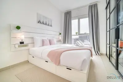 a white bedroom with a large bed and a window at Jovial 1BR at Collective Tower 2 Mohammed Bin Rashid City by Deluxe Holiday Homes in Dubai
