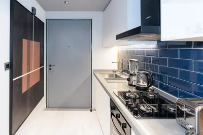 a kitchen with a stove and a blue tiled wall at Lux Studio in Downtown, 5 mins to Burj Khalifa & Dubai Mall - MAG318 in Dubai