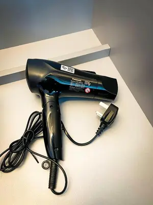 a black hair dryer and a phone on a counter at Lux Studio in Downtown, 5 mins to Burj Khalifa & Dubai Mall - MAG318 in Dubai